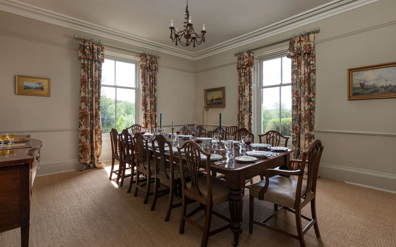 Large dining room with view over the table out of the two windows in Crookham Eastfield Farmhouse 